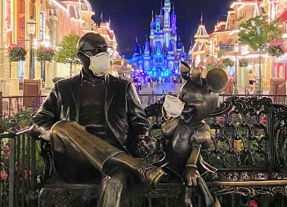 “Sharing the Magic” statue of Roy Disney and Minnie Mouse at Walt Disney World. wearing N95 masks during the Covid-19 (Corona Virus) outbreak.