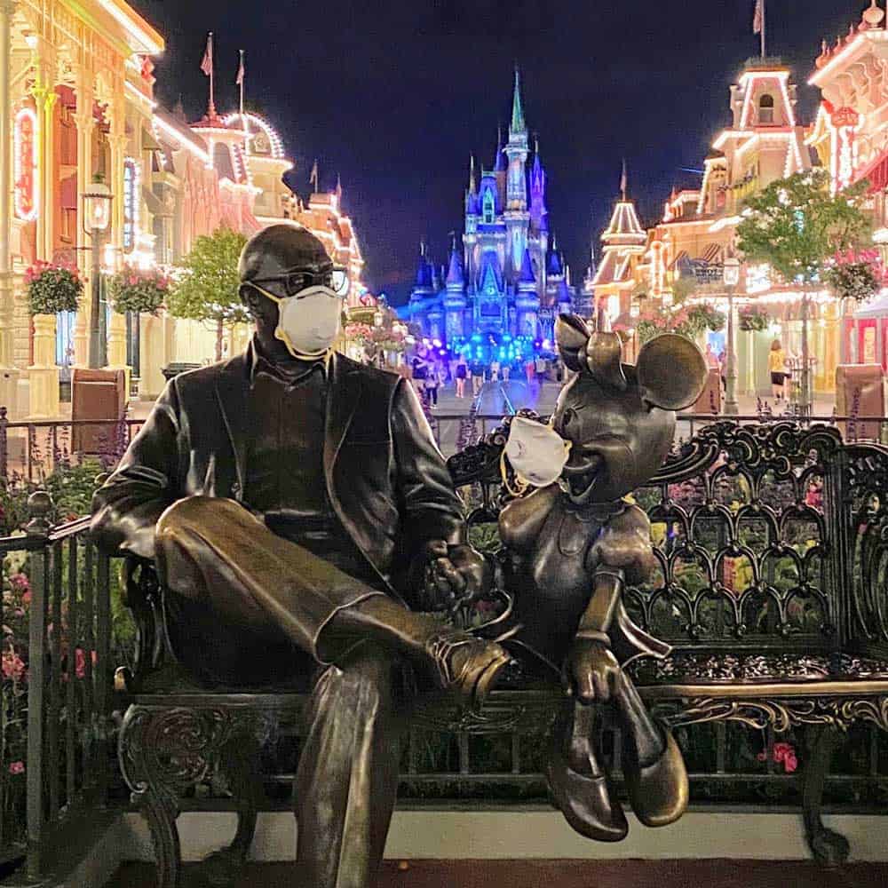 “Sharing the Magic” statue of Roy Disney and Minnie Mouse at Walt Disney World. wearing N95 masks during the Covid-19 (Corona Virus) outbreak.